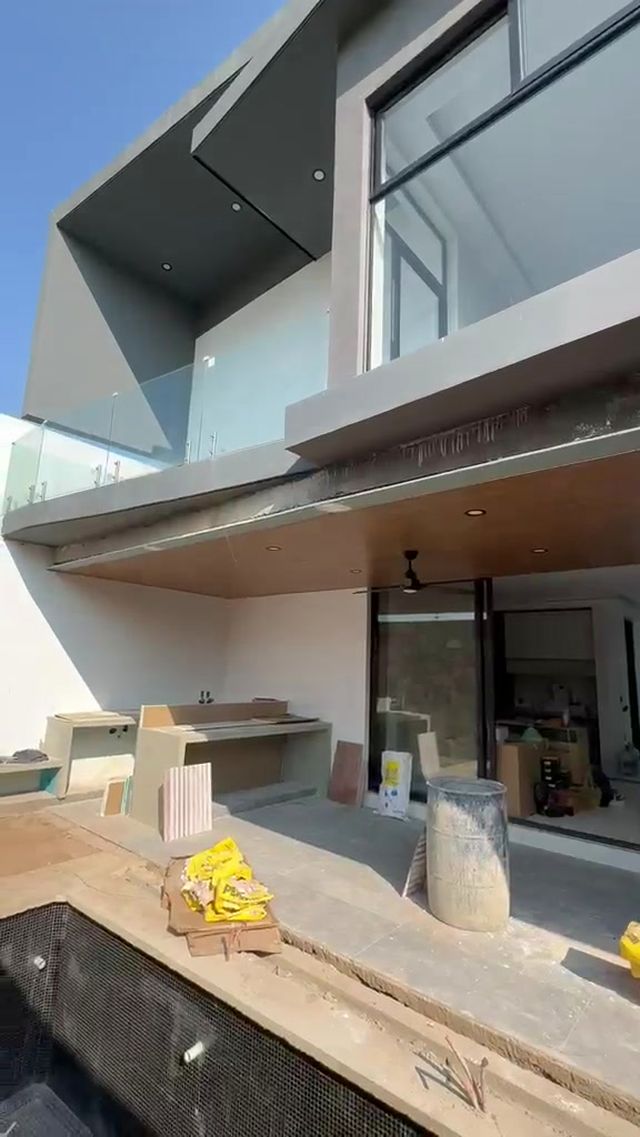 Terraza posterior con barandal de cristal y plafón de madera